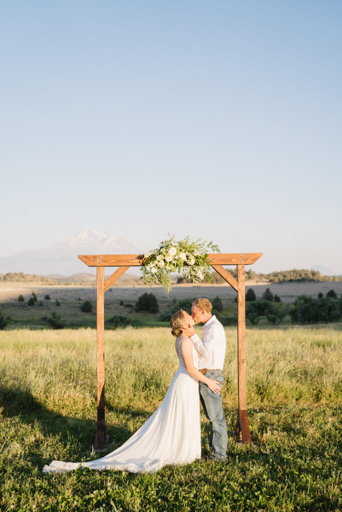 Couple standing at altar with mountain in background.